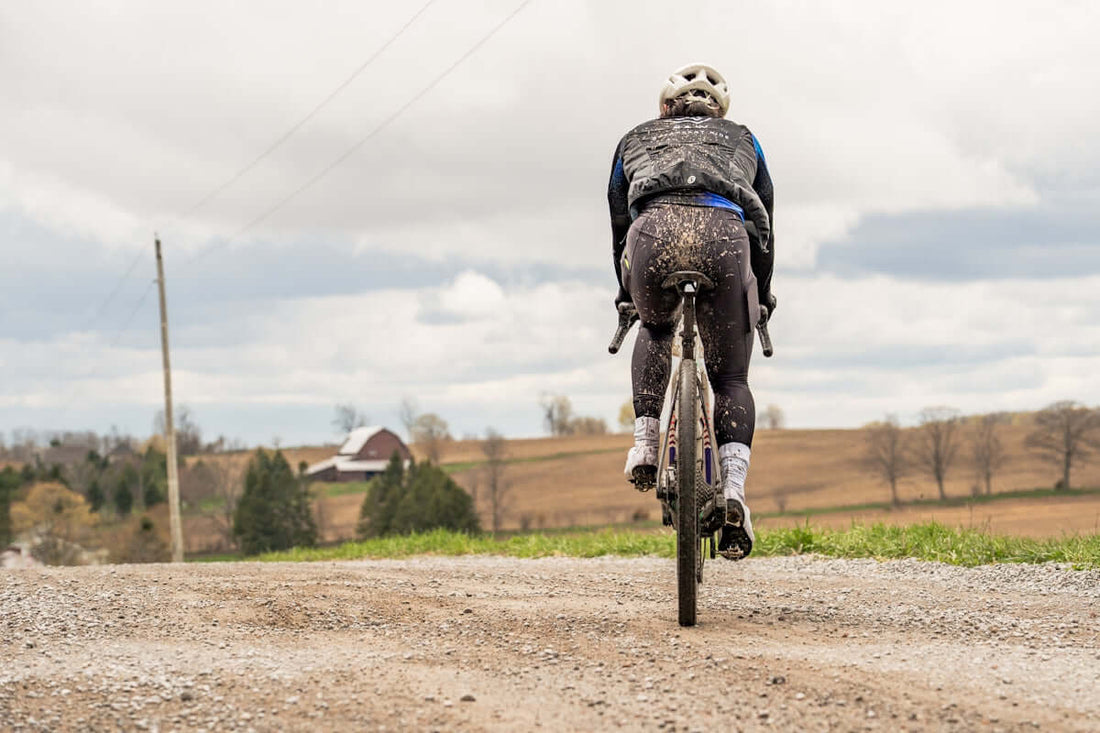 Cyclist riding on a muddy gravel road