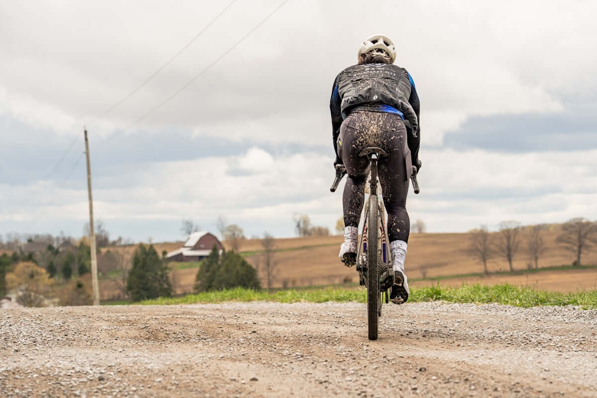 Cyclist riding on a muddy gravel road