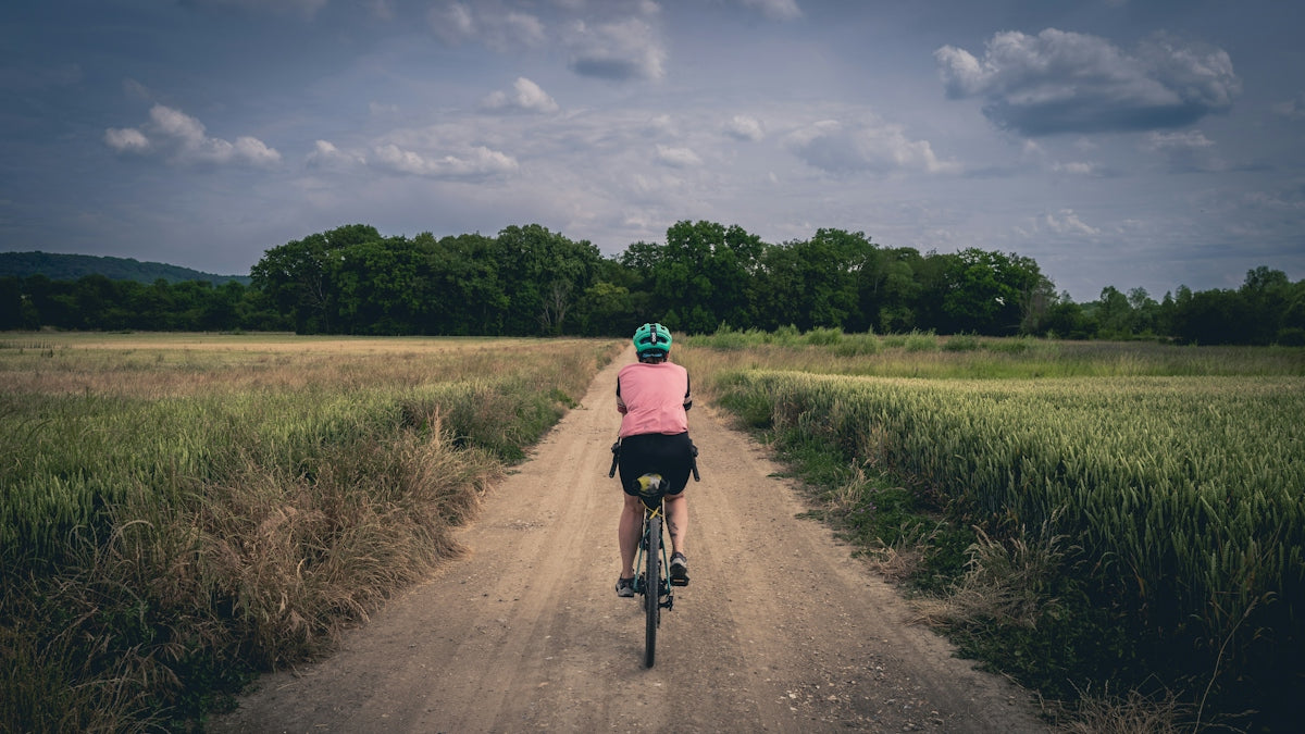 a person riding a bike down a dirt road